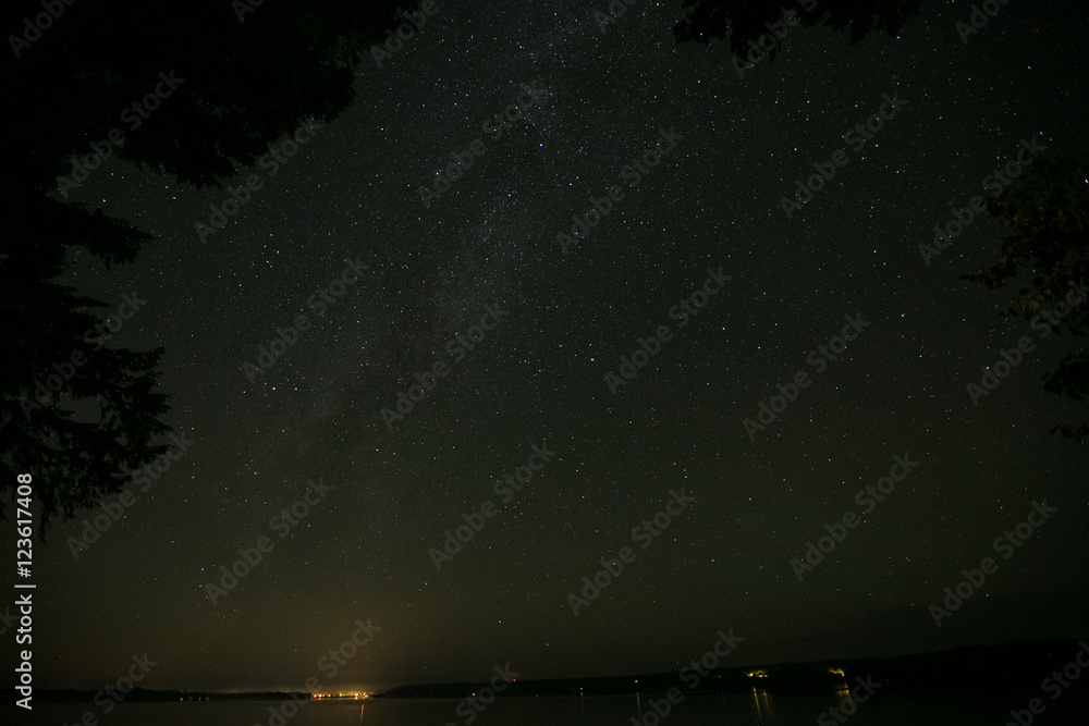 Long exposure of the stars lake and trees Long exposure of the stars lake and trees