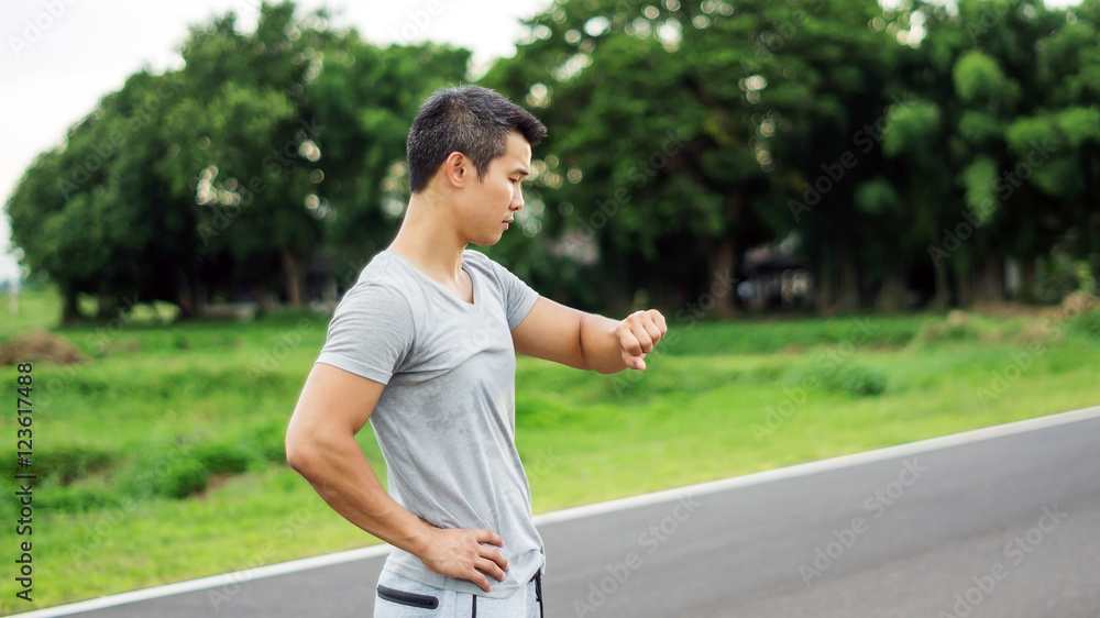Asian man prepares for a workout at the public park, soft focus. Asian man prepares for a workout at the public park, soft focus.