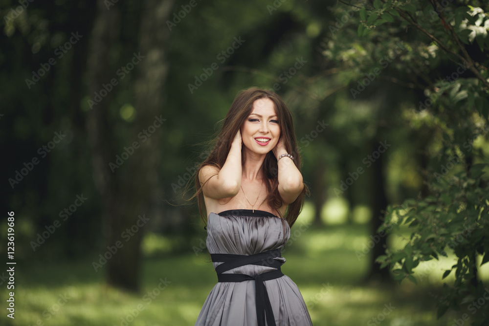 Beauty Romantic Girl Outdoors. Teenage Model with Casual Dress in park. Blowing Long Hair. Beauty Romantic Girl Outdoors. Teenage Model with Casual Dress in park. Blowing Long Hair.