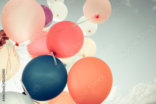 Colorful balloons flying on sky with a retro vintage filter effect. The concept of happy birthday in summer and wedding honeymoon party - usage for background (vintage color tone)