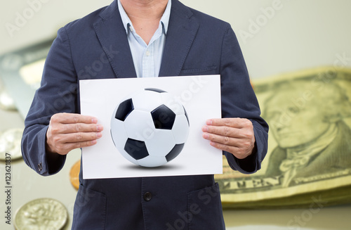 Businessman hand holding card board with soccer ball