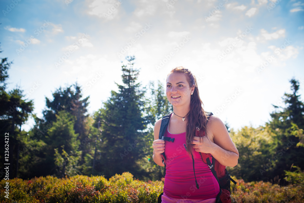 Beautiful young woman/girl/female tourist during hiking the mountain/trekking/backpacking trip on a beautiful sunny summer day Beautiful young woman/girl/female tourist during hiking the mountain/trekking/backpacking trip on a beautiful sunny summer day