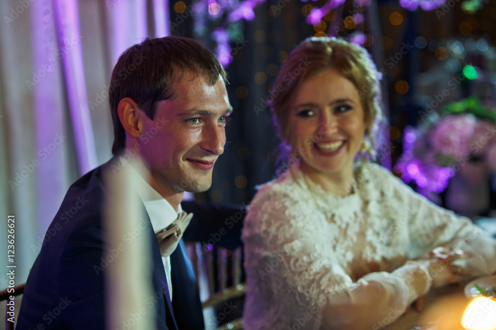 Bride smiles admiring a handsome groom in the restaurant Bride smiles admiring a handsome groom in the restaurant