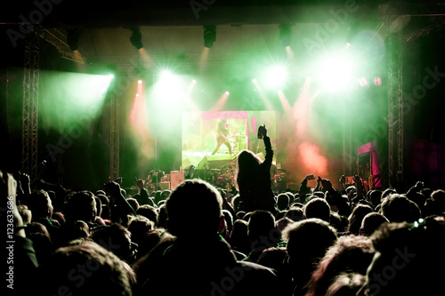 Fototapeta Naklejka Na Ścianę i Meble -  Rock concert, silhouettes of happy people raising up hands