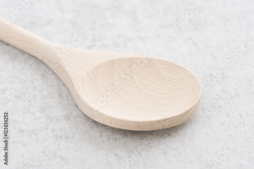 Wooden spoon on stone table. Traditional cooking equipment. Wood kitchenware object used for food, serving or cooking.