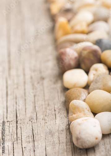 Stones on wooden background, concept of harmony and tranquility. Decoration with stone pebbles as natural design backdrop with copy space.