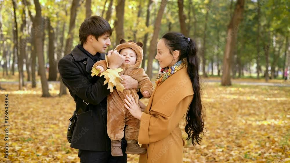 Family in the forest. Baby boy with autumn leaves in his hand, in the arms of father's. Family in the forest. Baby boy with autumn leaves in his hand, in the arms of father's.