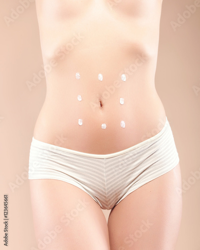 woman body care with cream dots around belly © gangiskhan