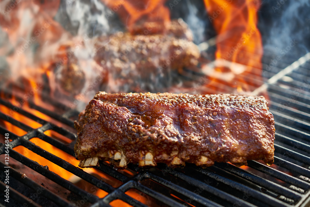 grilling baby back pork ribs over flaming grill grilling baby back pork ribs over flaming grill