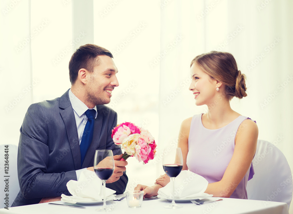 smiling man giving flower bouquet at restaurant smiling man giving flower bouquet at restaurant