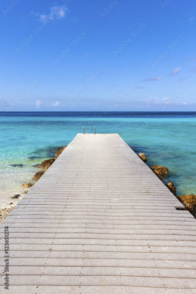 Jetty at the Caribbean sea leading into turquoise water