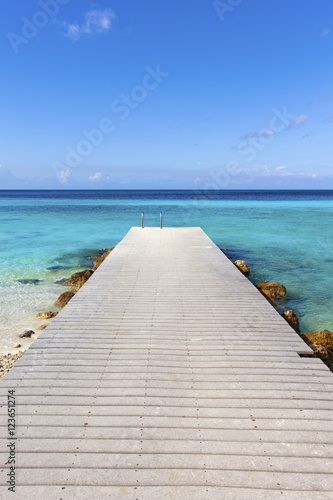 Fototapeta Jetty at the Caribbean sea leading into turquoise water