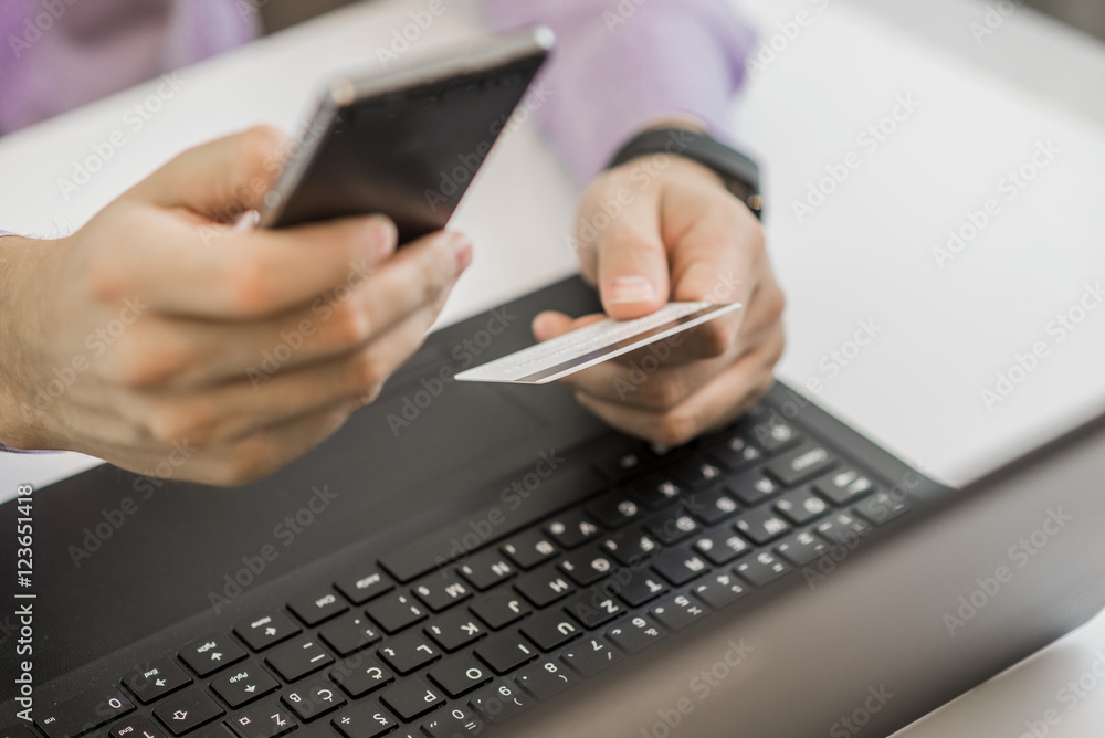 Hands holding plastic credit card and using laptop. Hands holding plastic credit card and using laptop.
