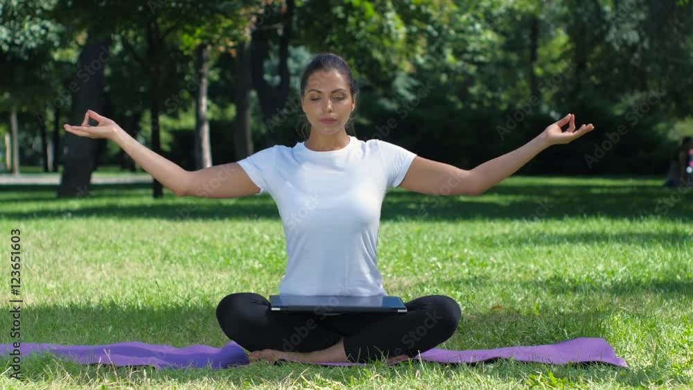 Woman working with laptop sitting lotus pose Woman working with laptop sitting lotus pose