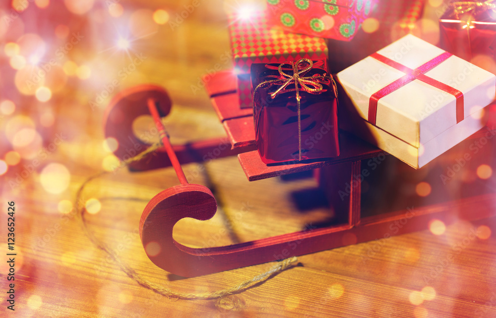 close up of christmas gift boxes on wooden sleigh