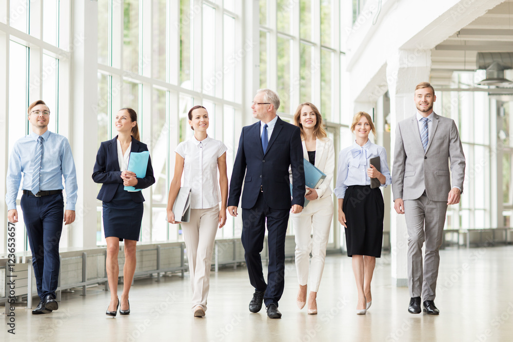 Obraz premium business people walking along office building