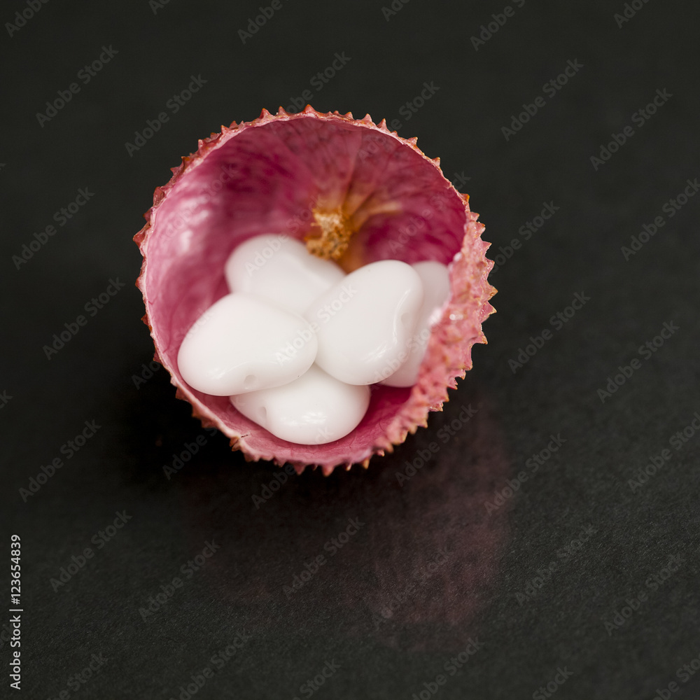 Litchi peel with heart shaped agate on black background Litchi peel with heart shaped agate on black background