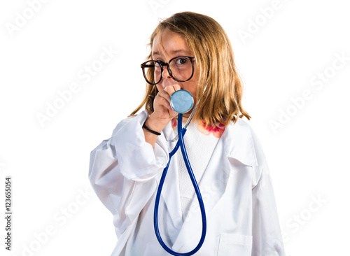 Little girl playing to be a doctor and holding a otoscope