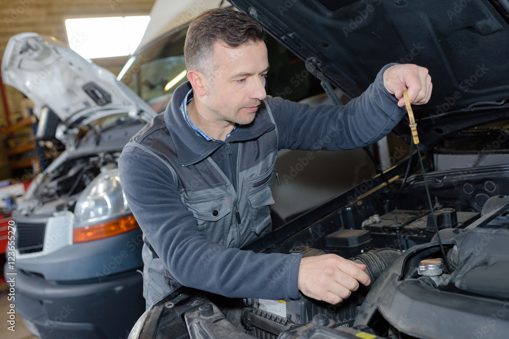 car mechanic replacing oil on engine in garage car mechanic replacing oil on engine in garage