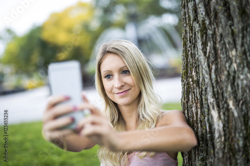 happy woman posing against a tree photo