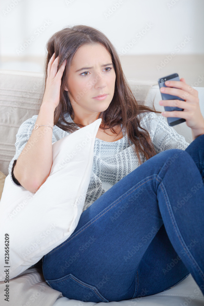 Girl looking at cellphone, worried expression Girl looking at cellphone, worried expression