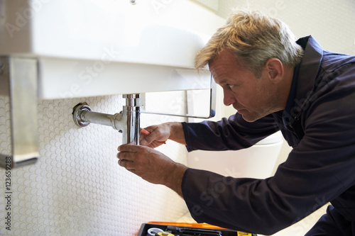 Photos Plumber Working On Sink In Bathroom