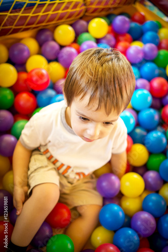 Happy cute child playing and having fun at kindergarten with col