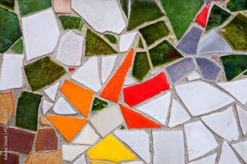 Random broken tiles surface covering a building facade. photo