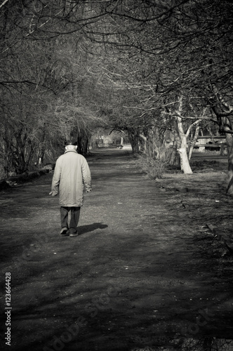 Old man goes alone through the park. Black and white © jetrel2