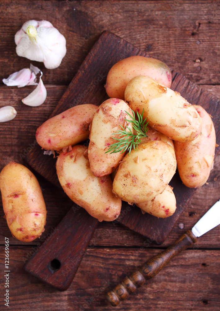 young potatoes in a wooden plate on a wooden background young potatoes in a wooden plate on a wooden background