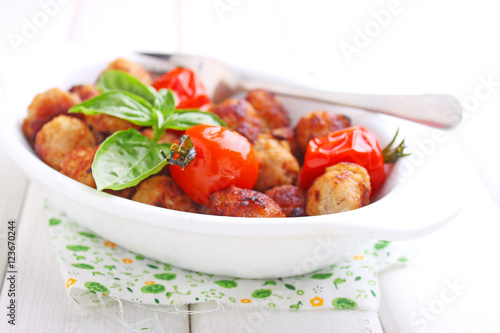 Meatballs with tomato in a white dish on a white background. selective focus.