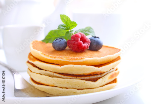 Pancake with berries blueberries in a plate on a white background