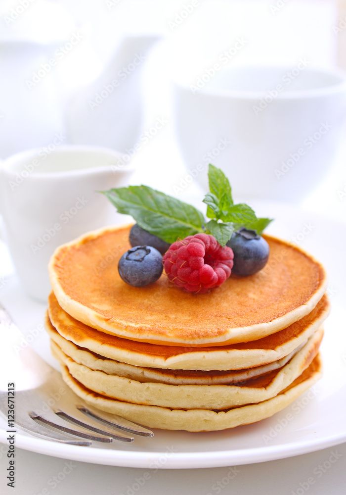 Pancake with berries blueberries in a plate on a white background Pancake with berries blueberries in a plate on a white background