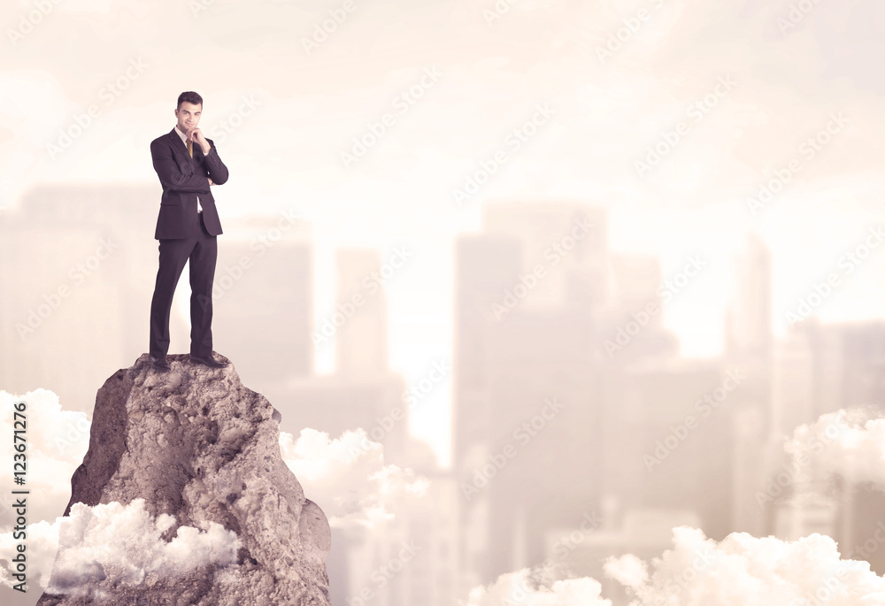 Confident businessman on dangerous cliff Confident businessman on dangerous cliff