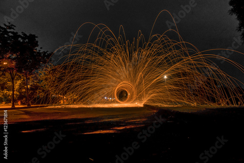 Showers of hot glowing sparks from spinning steel wool. 