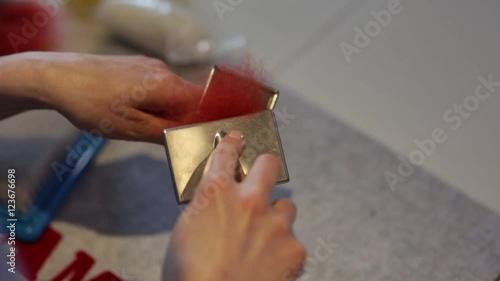 Чесание волокон окрашенной шерсти ручными кардами в процессе работы по изготовлению войлочного изделия photo