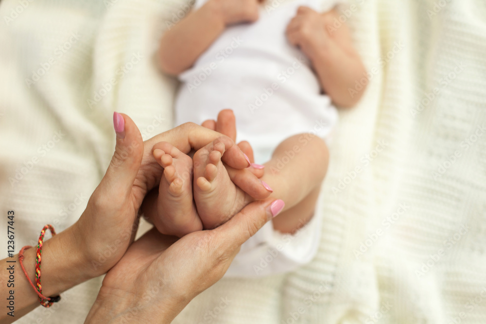 Hand holding little baby's legs Hand holding little baby's legs