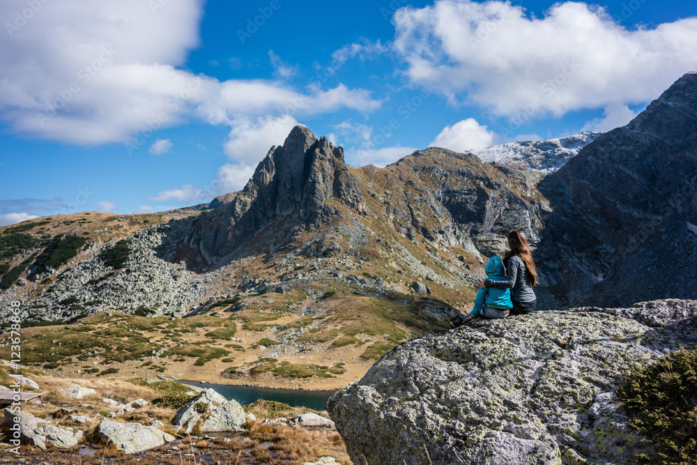 Frau mit Kind rastet bei Wanderung in den Bergen vom Rila Gebirge Frau mit Kind rastet bei Wanderung in den Bergen vom Rila Gebirge