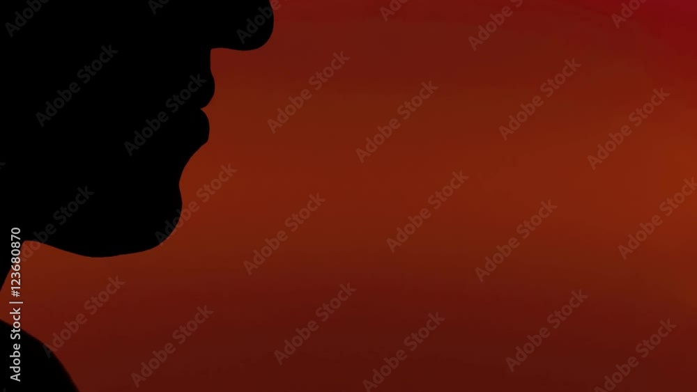 A woman blowing into a whistle. Clear silhouette shot, red background.
A woman blowing into a whistle. Clear silhouette shot, red background.
