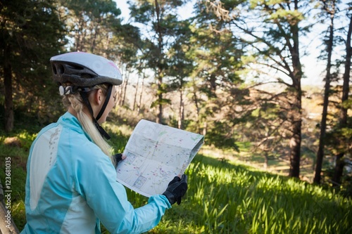 Female mountain biker looking at map