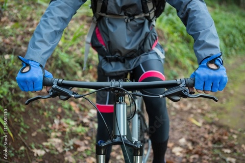 Mid section of male mountain biker riding bicycle