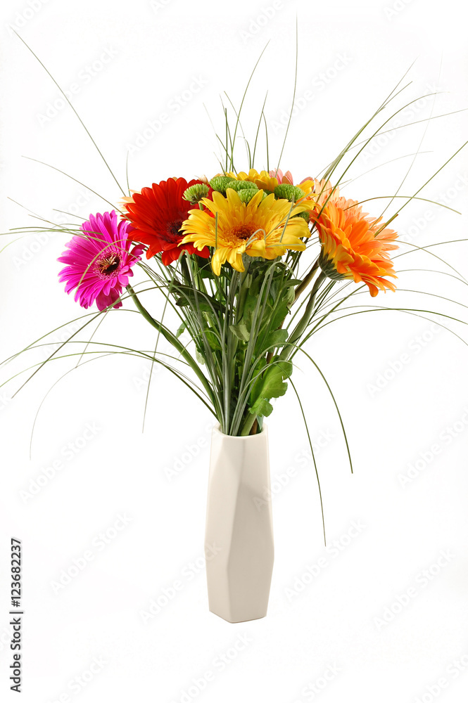 Assorted gerbera bouquet in a minimalist assymetrical white vase, isolated on white background
