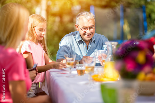 grandfather playing cards outdoors.