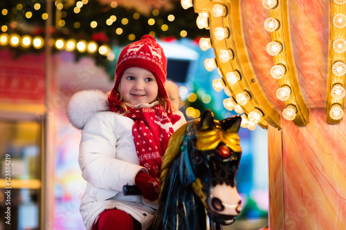 Child riding carousel on Christmas market © famveldman