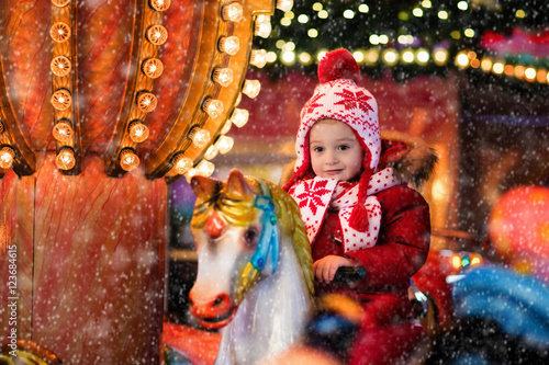 Child riding carousel on Christmas market