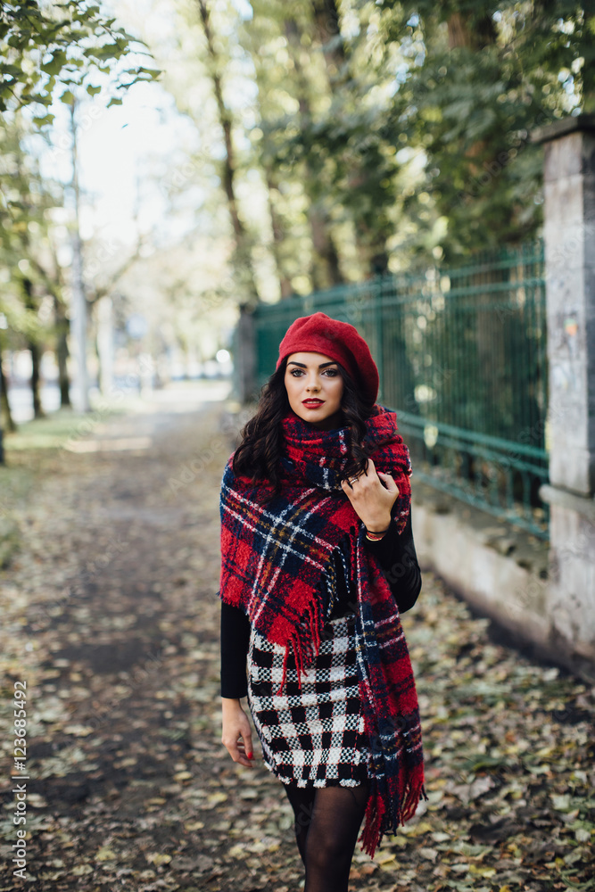 Beautiful happy girl in red hat and scarf walking in the autumn park Beautiful happy girl in red hat and scarf walking in the autumn park