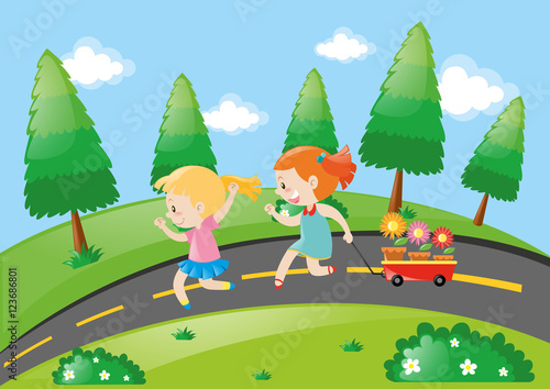 Two girls pulling wagon on the road