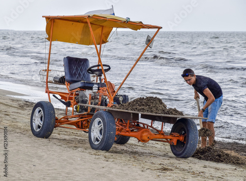 The car for garbage collection from the beach. Cleaning on the beach, clean beach from mud and waste photo