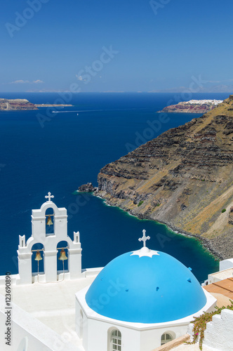 Blue-domed chapel with ochre bell tower in Oia