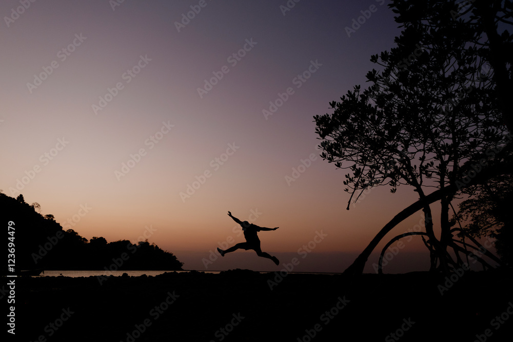 silhouette of man jump at the beach in evening